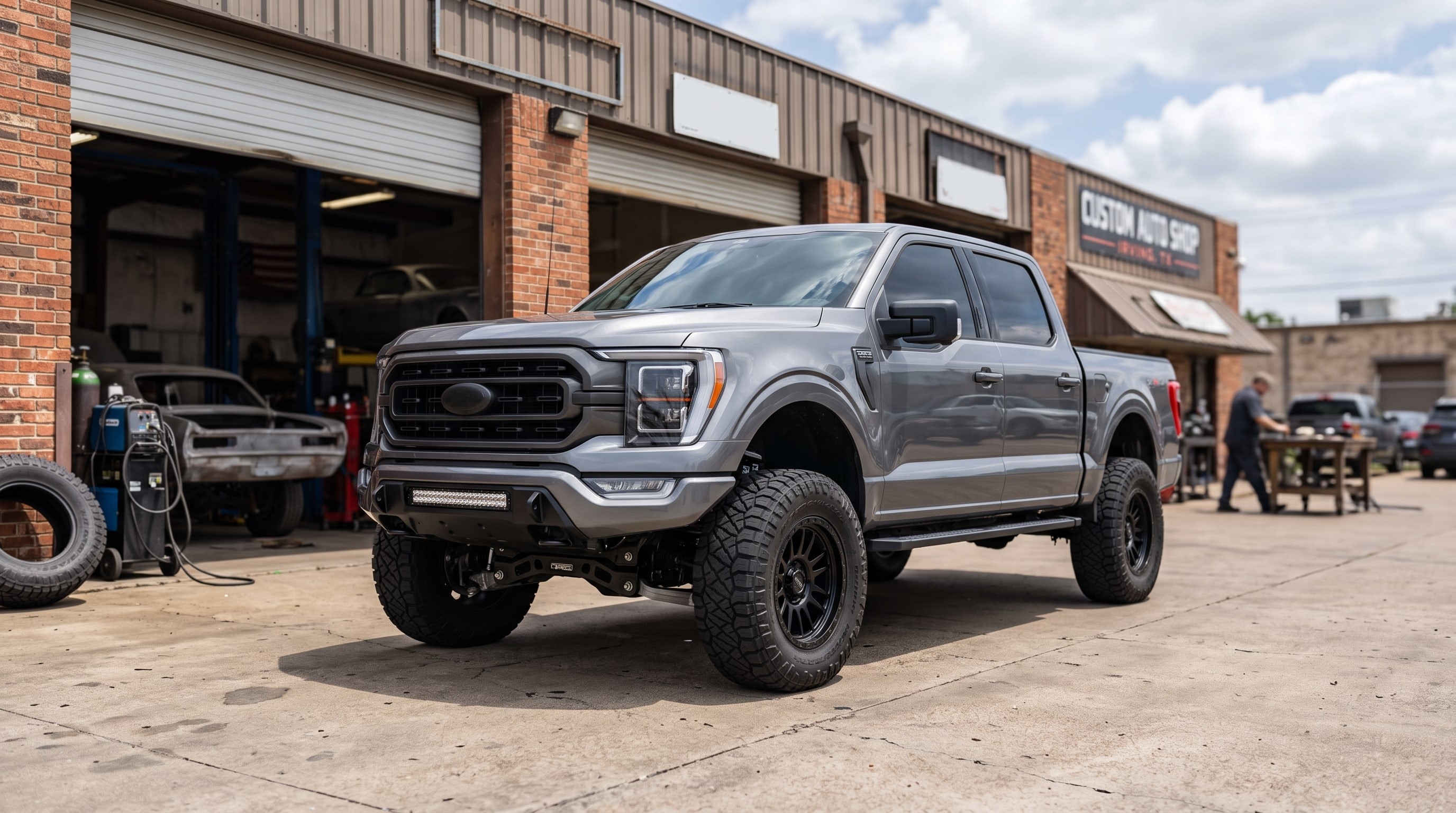 A lifted Ford F-150 showcasing professional Cognito lift kits installation parked outside our shop — Metroplex Customs, Irving TX