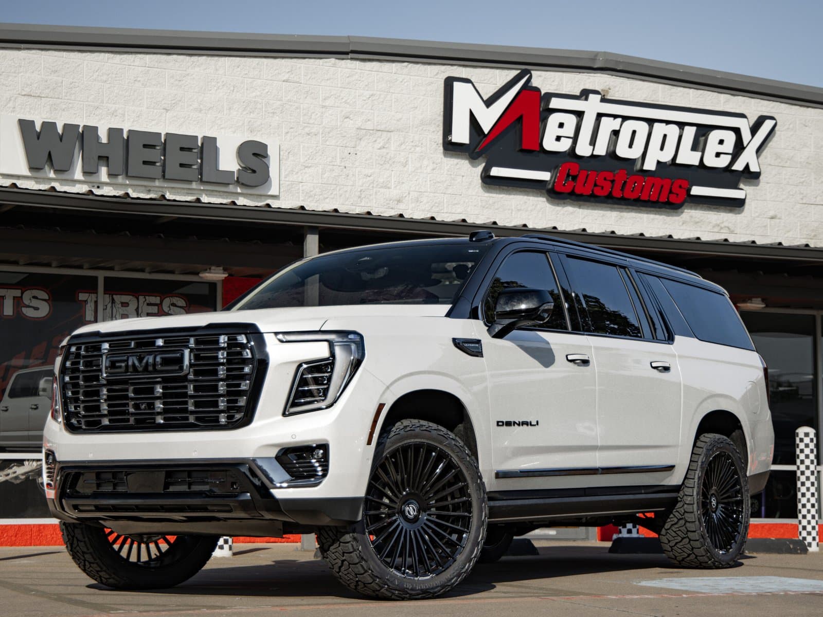 White GMC Yukon Denali with custom black wheels & off-road tires - Irving TX