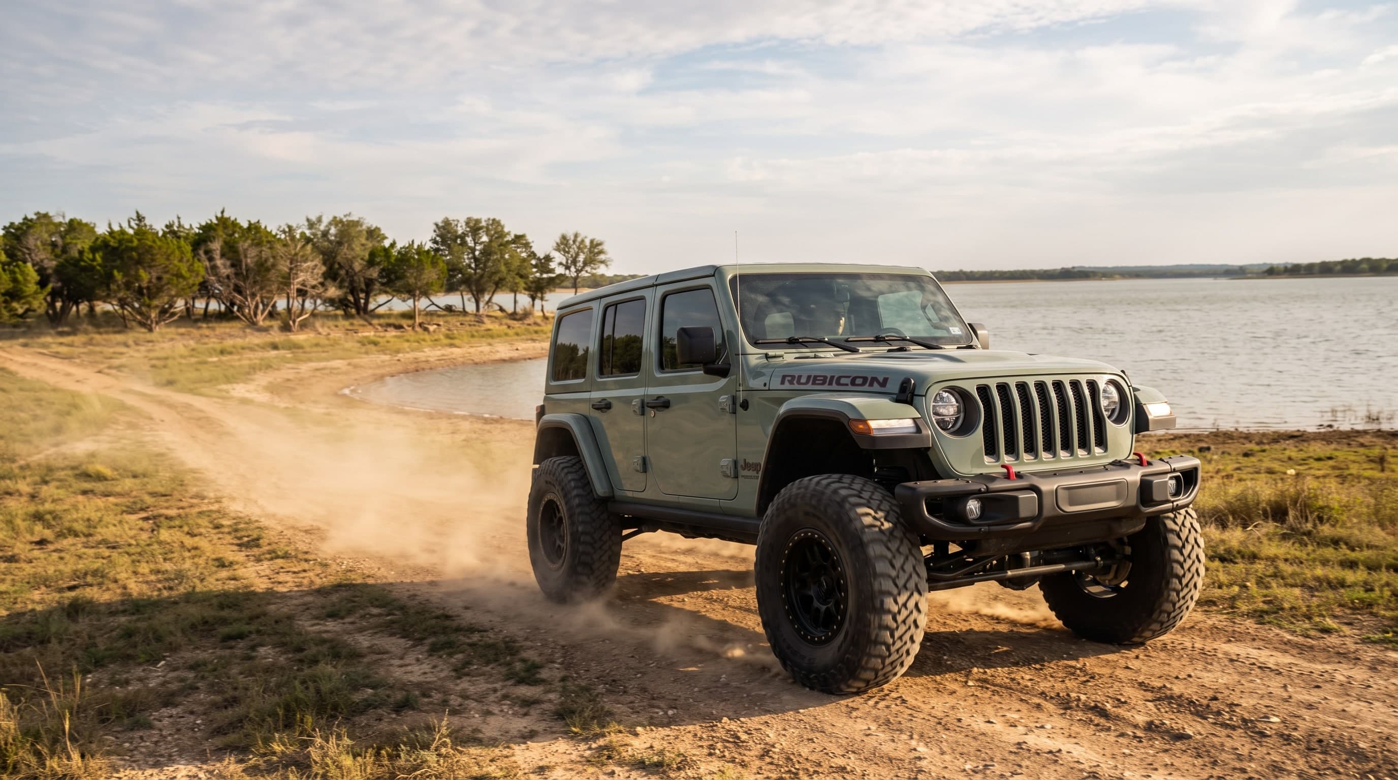 Lifted Jeep Wrangler Rubicon on 37-inch tires on a lakeside dirt trail at Grapevine Lake, Texas